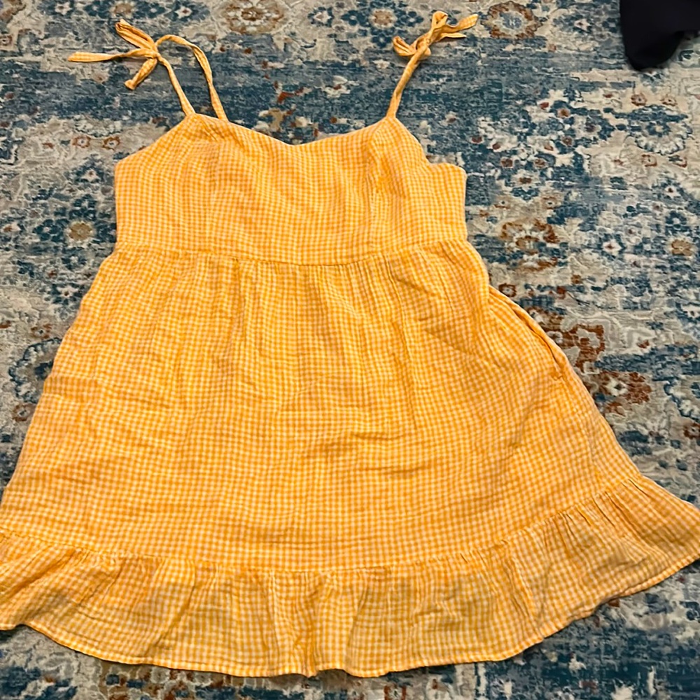 A orange and white plaid sundress with tie straps.